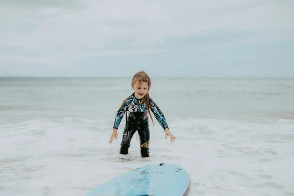 Girl surfing in wetsuit