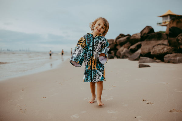 Kid walking on beach in hooded towel